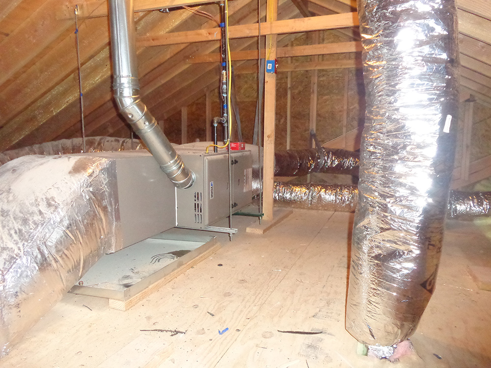 Central air conditioning unit in attic with insulated ducts, energy-efficient HVAC system installation.