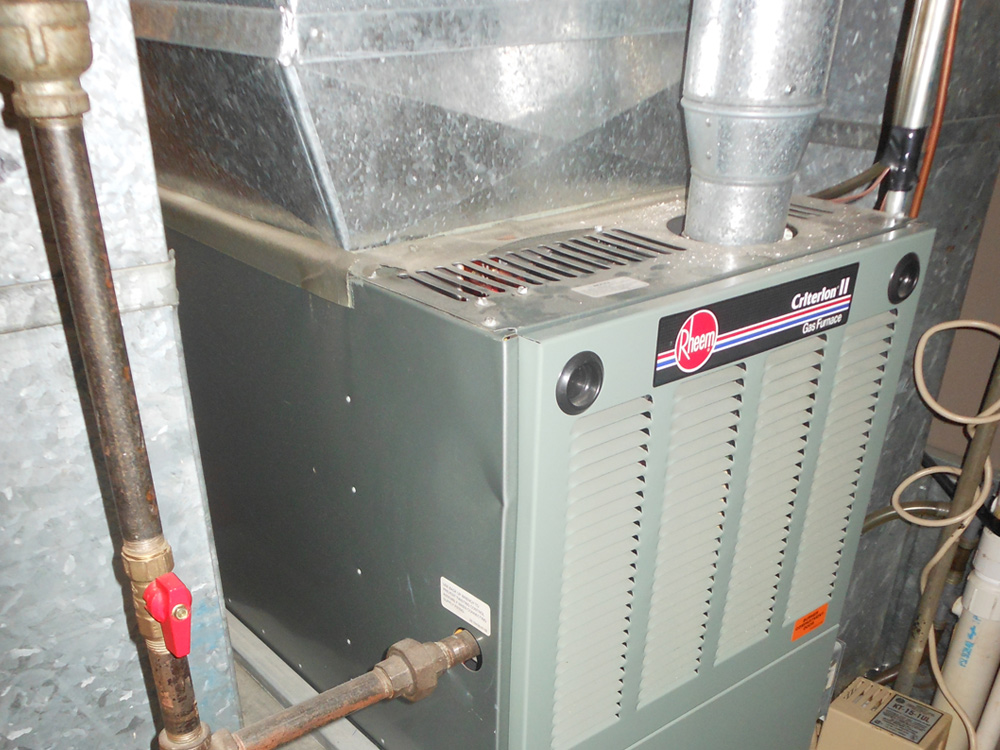 Central air conditioning unit with ducts, Rheem Criterion II gas furnace, efficient HVAC system in a home basement.