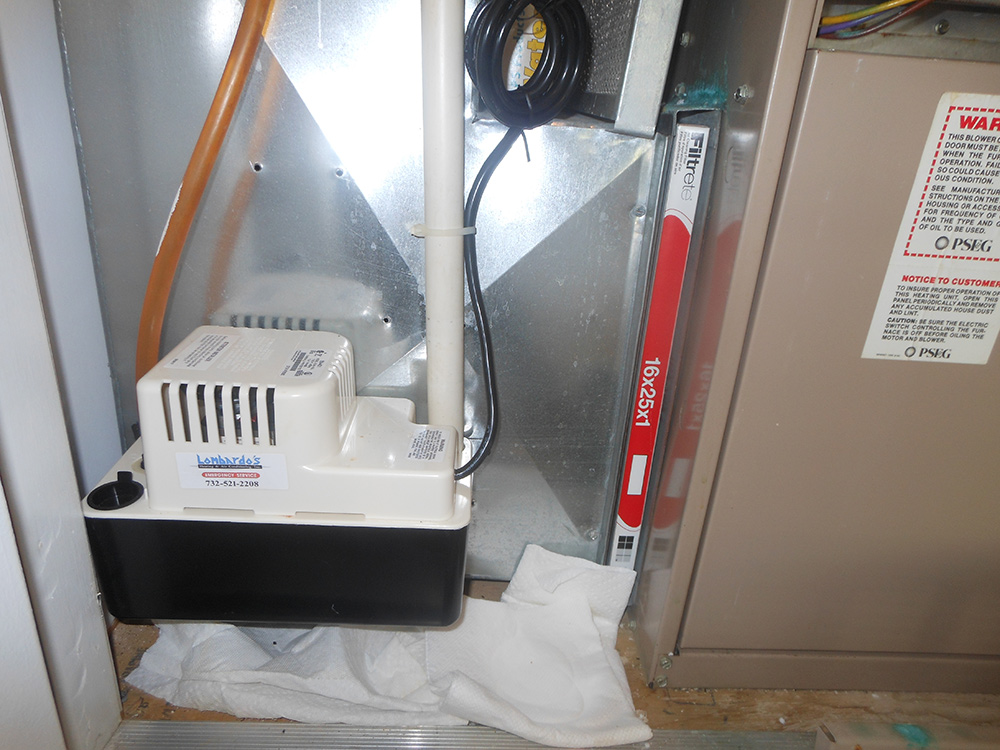 Central air conditioning unit with pump and air filter installation in a home HVAC system.